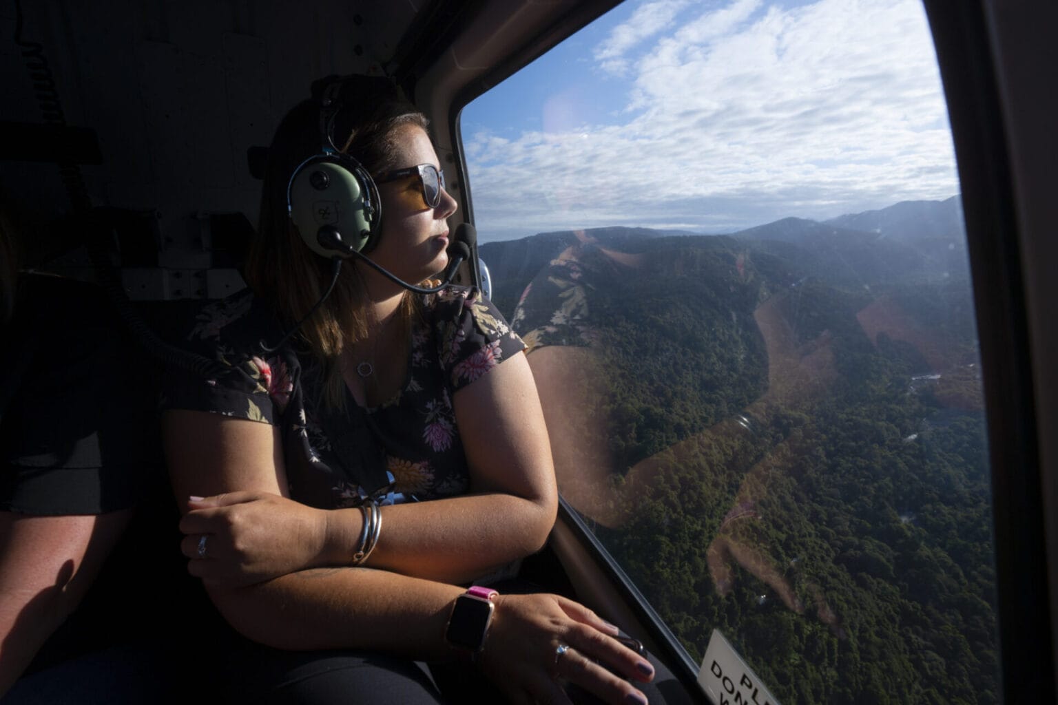 Woman looking out window of helicopter